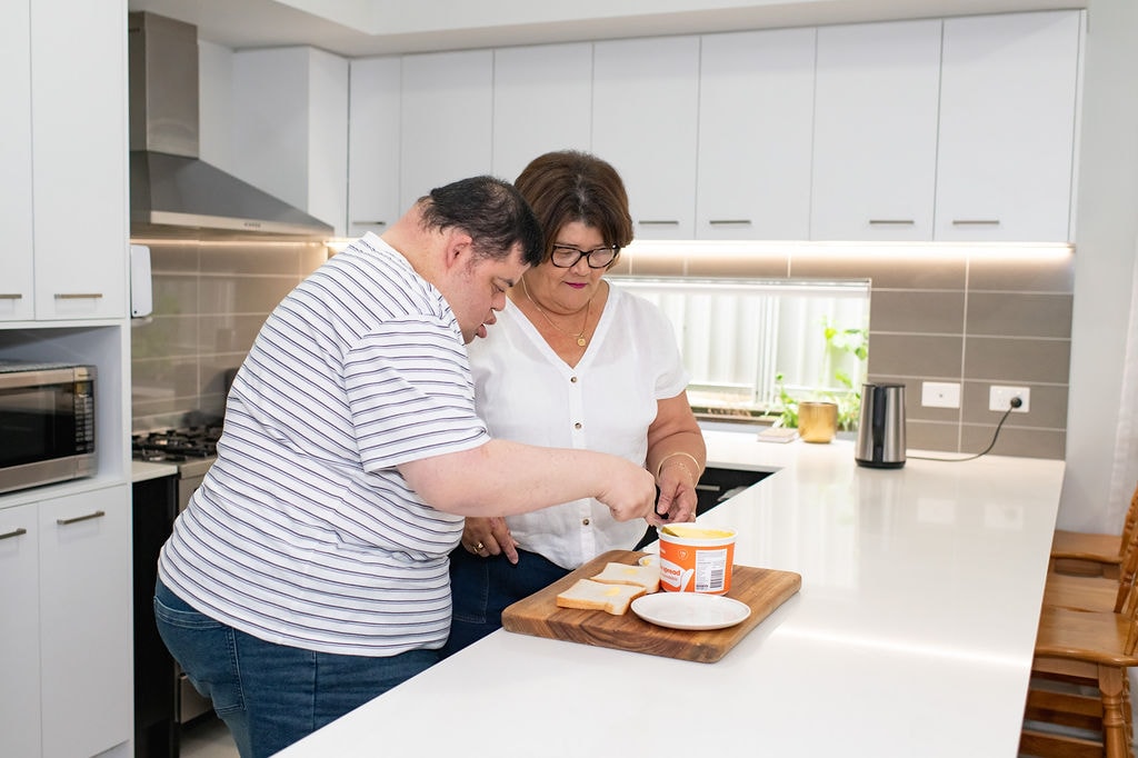 Kathleen Browne and her son preparing food together at the kitchen bench